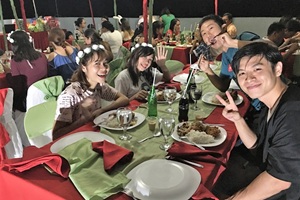 クリスマスパーティーの食事風景。みんな笑顔でディナー