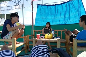 休日に屋上で英語ディスカッションをする生徒と講師