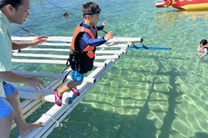 親子留学のスクールアクティビティで海に向かってジャンプする子ども（フィリピン留学中の思い出の一場面）