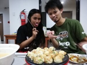 校内でタコ焼きパーティーを楽しむ様子、ドゥマゲテ留学の交流イベント