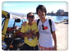 当校のトライシクルドライバーと並ぶKo Tanakaさん、ドゥマゲテ留学  