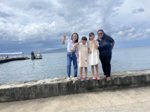 親子留学で先生と海沿いに立つMariko-family