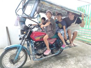 留学でトライシクルに乗るMariko-family