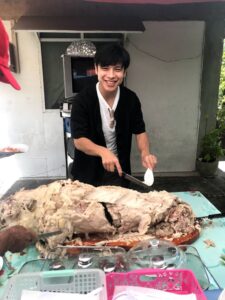 レチョン（豚の丸焼き）を切る体験の写真、ドゥマゲテ留学での文化体験